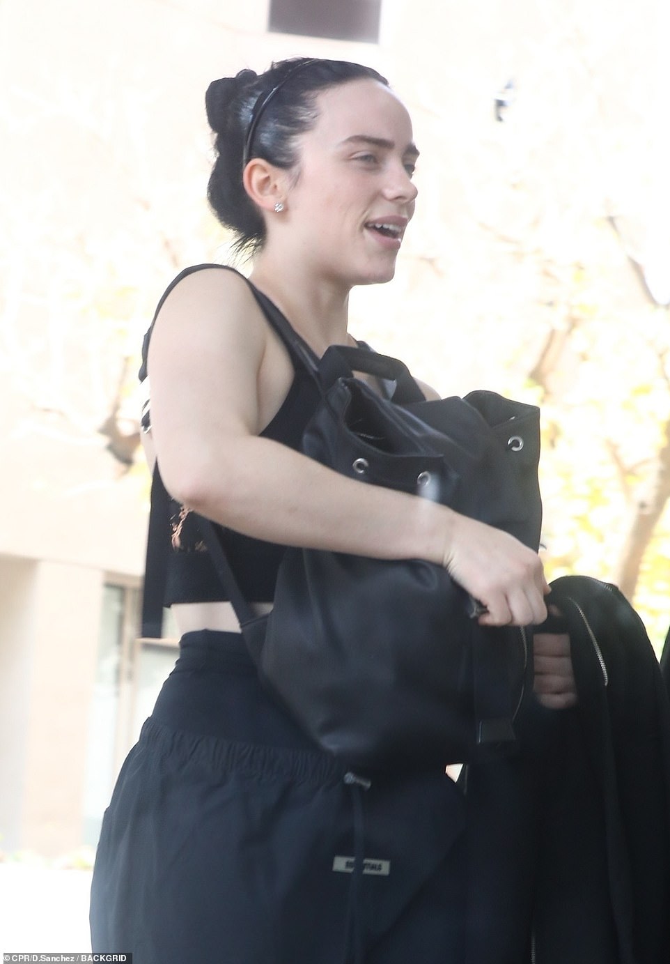 Sporty: While walking back to her car, alongside her personal trainer, the singer cut a sporty figure in a black sports bra, a pair of cropped black sweatpants from Essentials, white and grey sneakers and her hair up in a messy bun