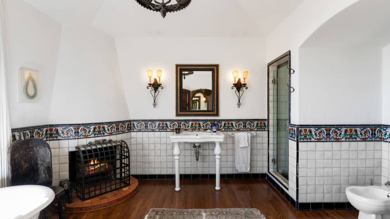 A bathroom includes a fireplace, walk-in shower and soaking tub.