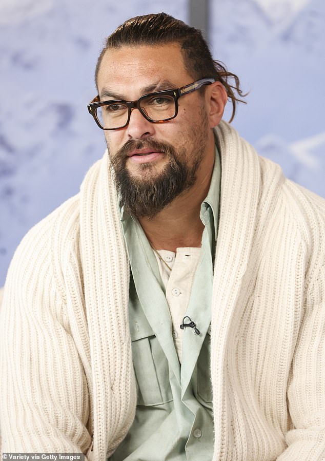 Casual: The 43-year-old Aquaman star also wore a pair of transition sunglasses and several rings. He held a purple water bottle and a brown film camera in his hand