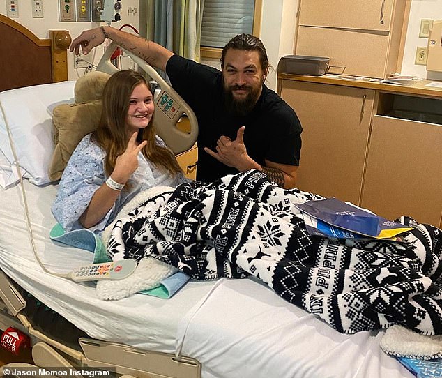 Hand signs: The Hawaii native flashed the shaka sign while a patient offered a peace sign during their visit