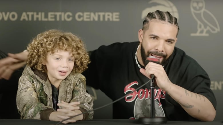 Rapper Drake and his son Adonis sitting at a press conference at Drake's OVO Athletic Centre in Toronto, Ont.