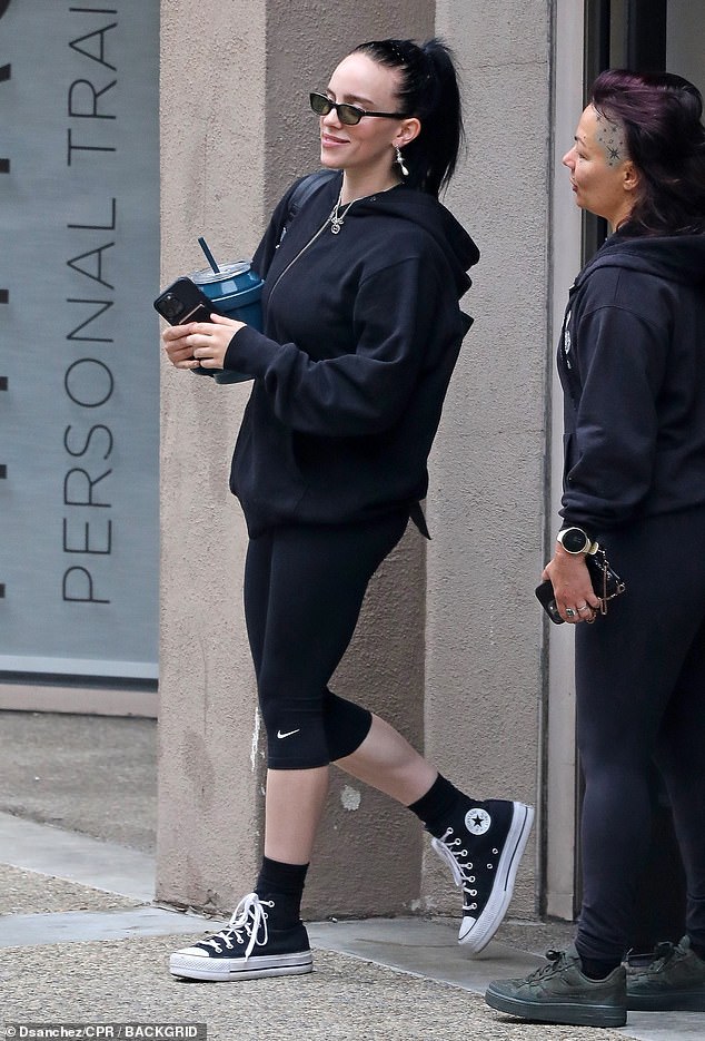 Fighting shape: The pop star donned a black jacket, leggings, and high-top Converse kicks for her workout