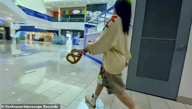 New accessory?: She hilariously totes a pretzel around the mall like a purse as she prepares to make her next move