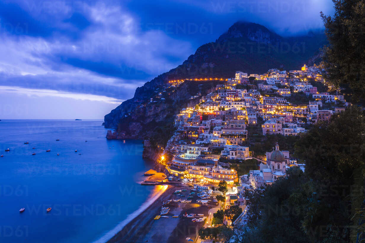 Cliff side buildings illuminated at night, Positano, Amalfi Coast, Italy stock photo