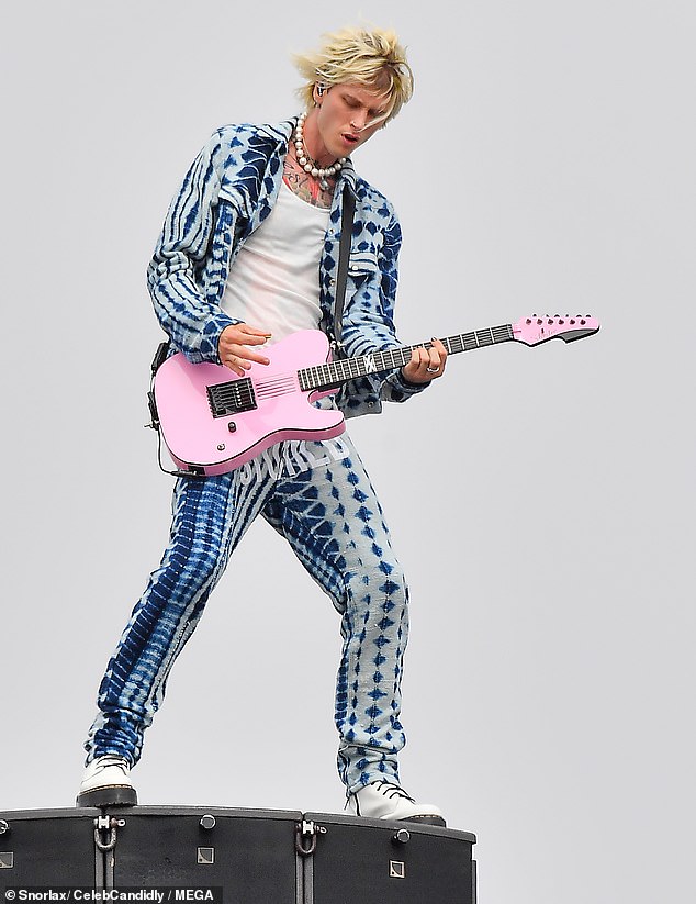 Show look: And for the performance MGK sported an eye-catching blue set with geometric shapes and white Doc Martens while playing his pink guitar