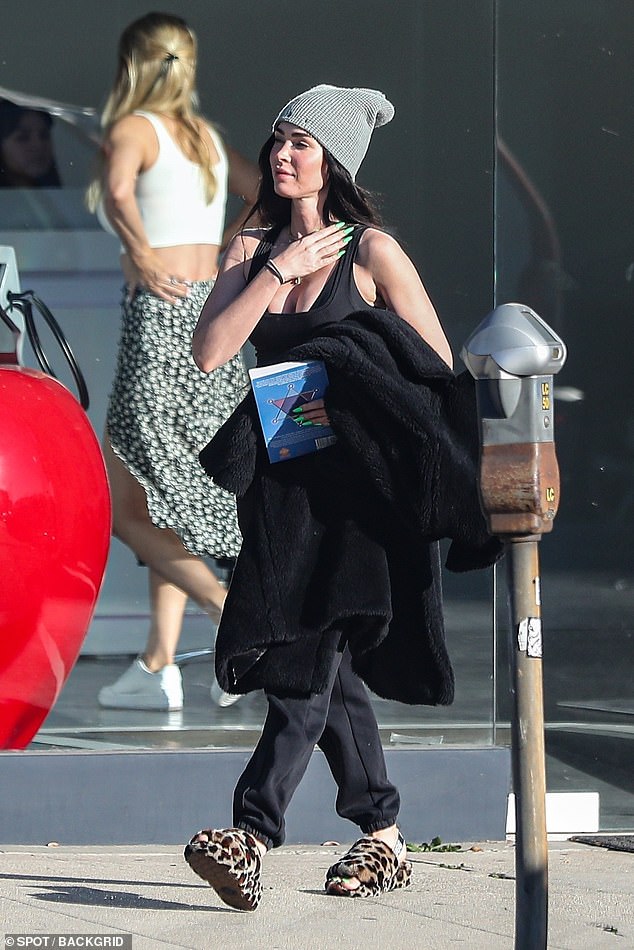 Staying warm: She also toted a warm fuzzy black coat on her arm. Keeping up with the laid-back look for the day, she sported a grey beanie atop her head