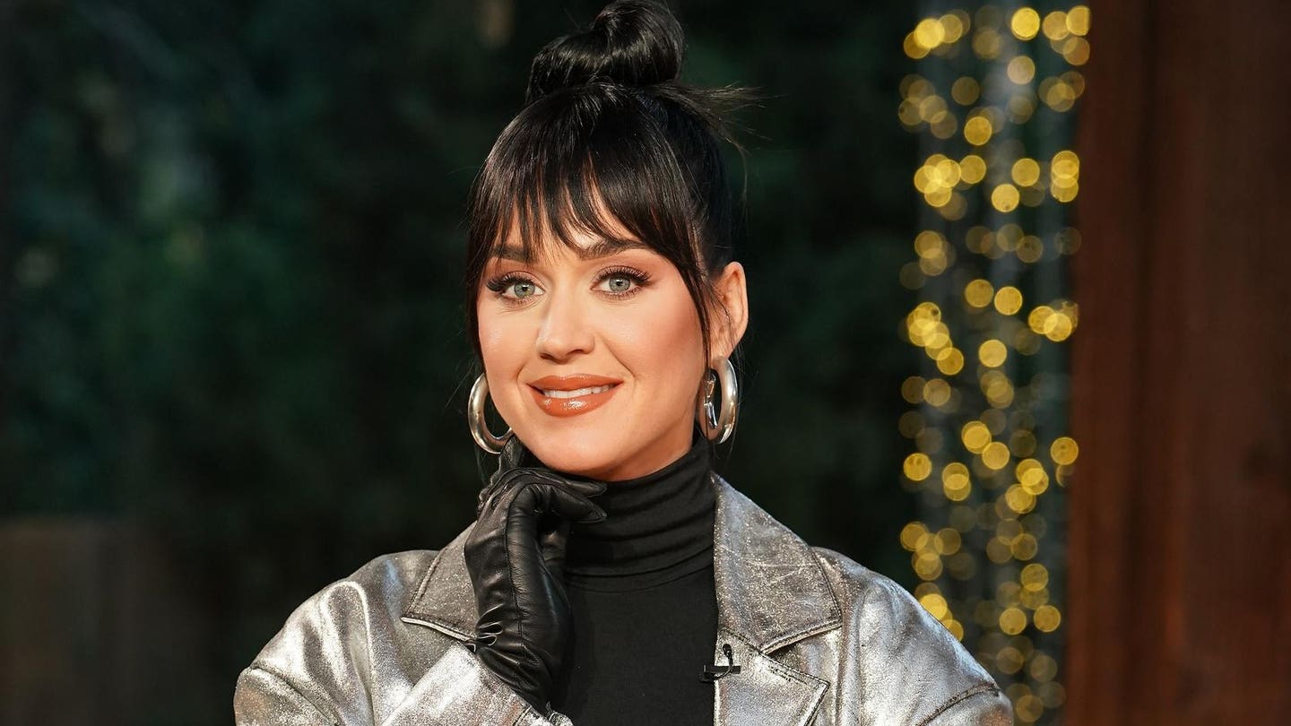 Katy Perry, wearing a black turtleneck and a sliver jacket, smiles during the Showstoppers round on "American Idol."