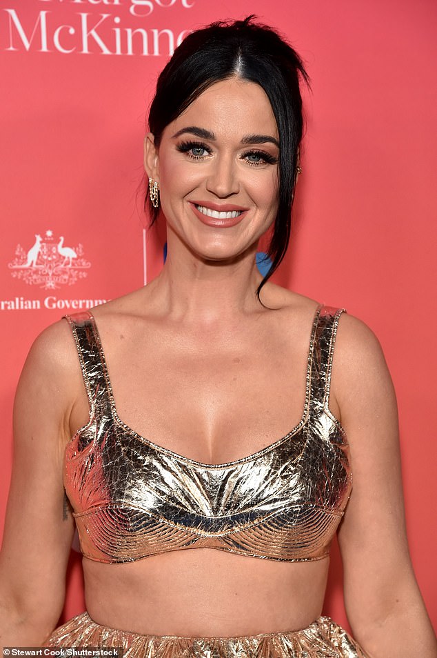 Glam: The California Gurls singer styled her black tresses pulled back with bangs framing her face and accessorized with coordinated silver bracelets and dangling earrings