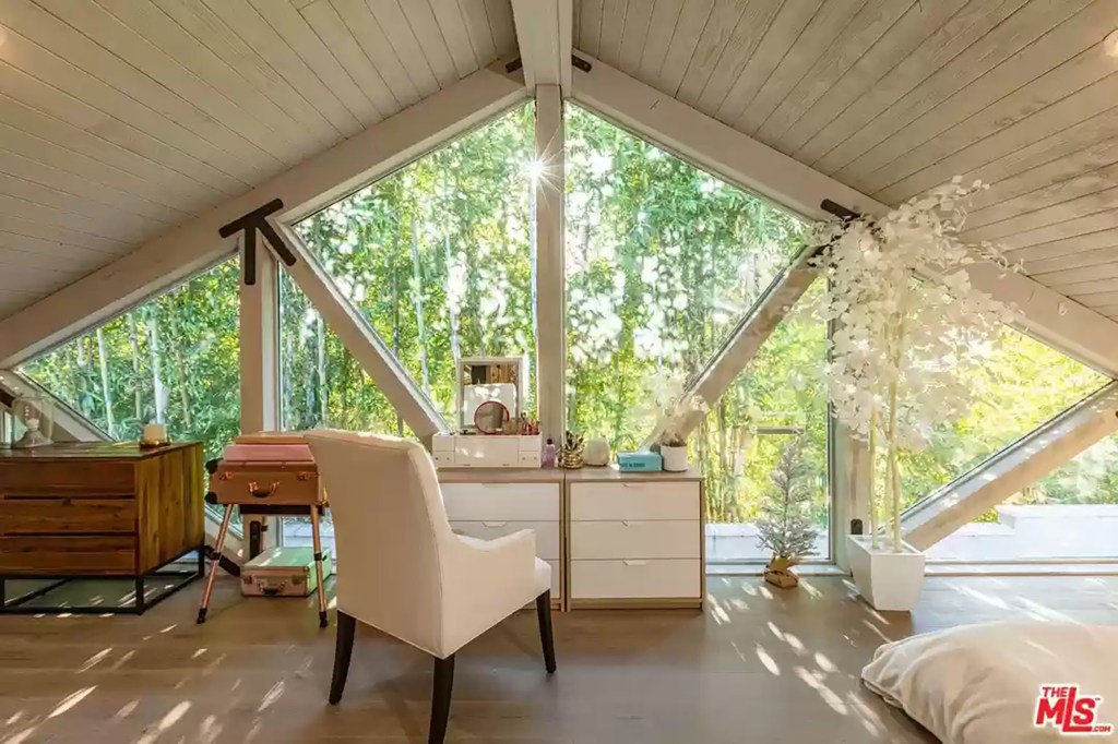 A set of stairs by the media center lead up to a treehouse-like loft office.