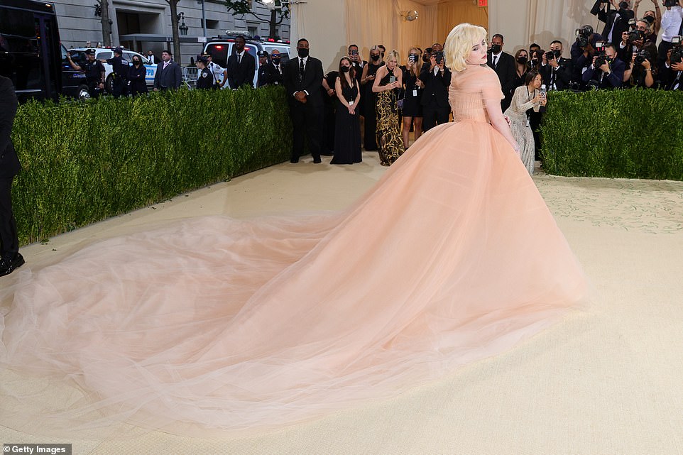 Strike a pose: The 19-year-old Grammy Award-winner wowed in a billowing peach ballgown with a lengthy train that trailed behind her as she posed for shutterbugs