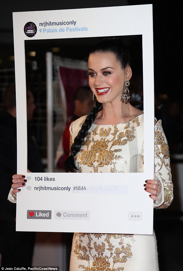 Snap and pose: The star looked through a prop and smiled as she posed on the red carpet