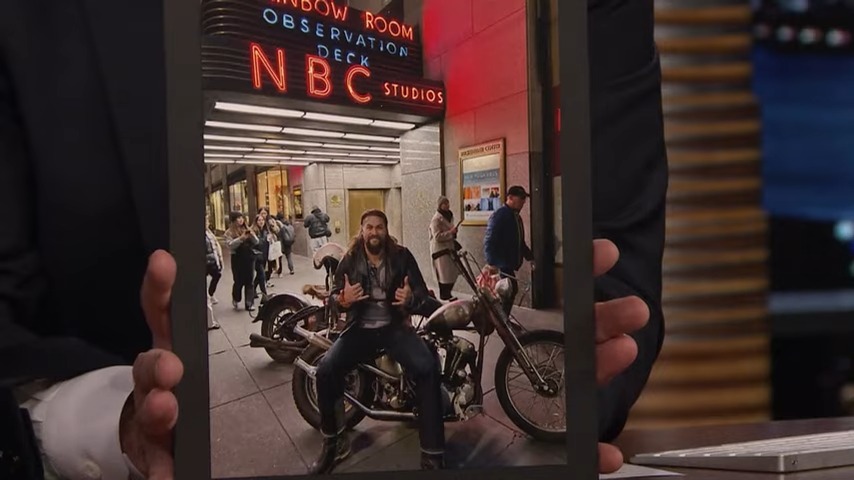 Jimmy Fallon holds up a photo of Jason Momoa on a motorcycle.