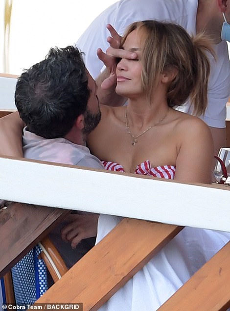 All wrapped up! JLo draped her toned arm around Ben and sat very still while he moved something out of her eye