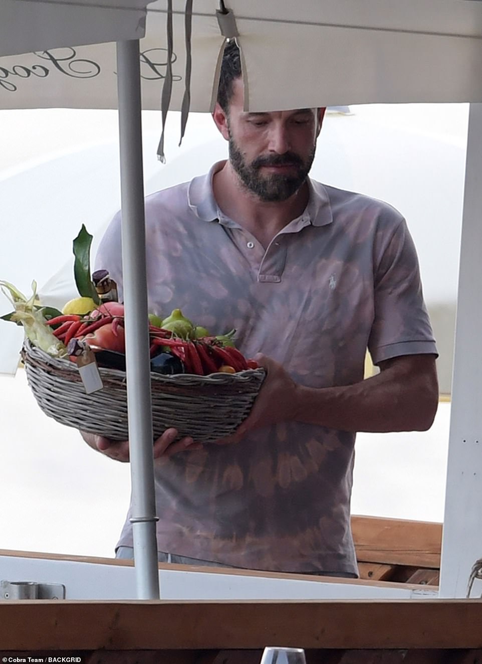 Bringing the goods: Ben seemed to have been tasked with carrying over a basket filled with fresh produce for the table