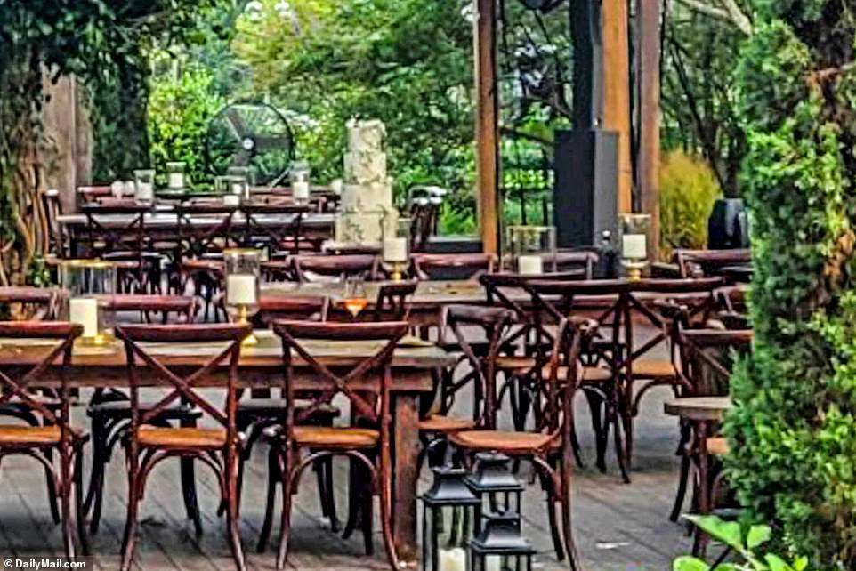 PICTURED: Rectangle wooden tables and chairs were arranged with simple oversized white candles as center pieces. A four-tier cake sat in the middle