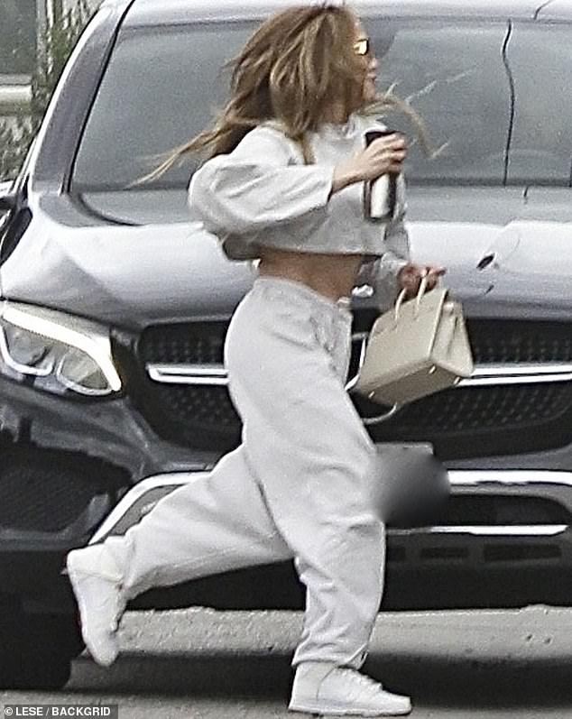 She lent her ensemble a dash of glitz with a gleaming pair of hoop earrings, bringing the look together with white sneakers and a designer purse