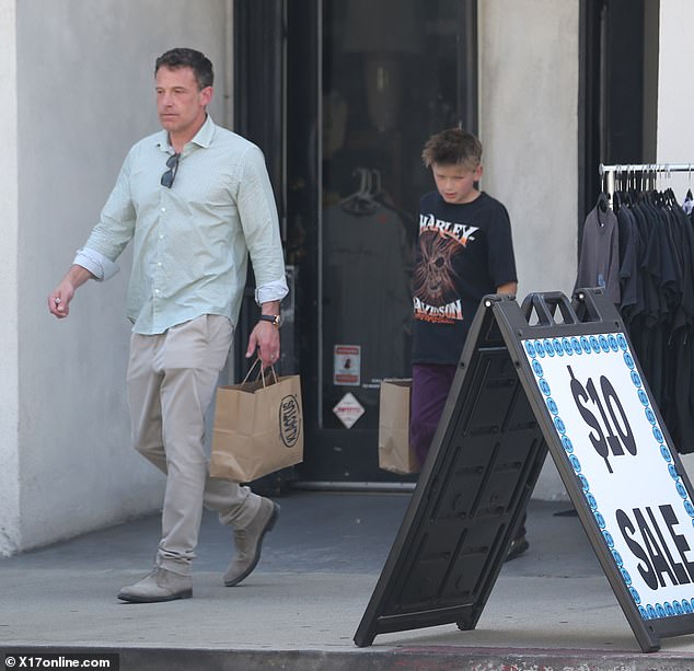 After sorting through the racks, the father and son were seen emerging from the establishment with shopping bags in hand