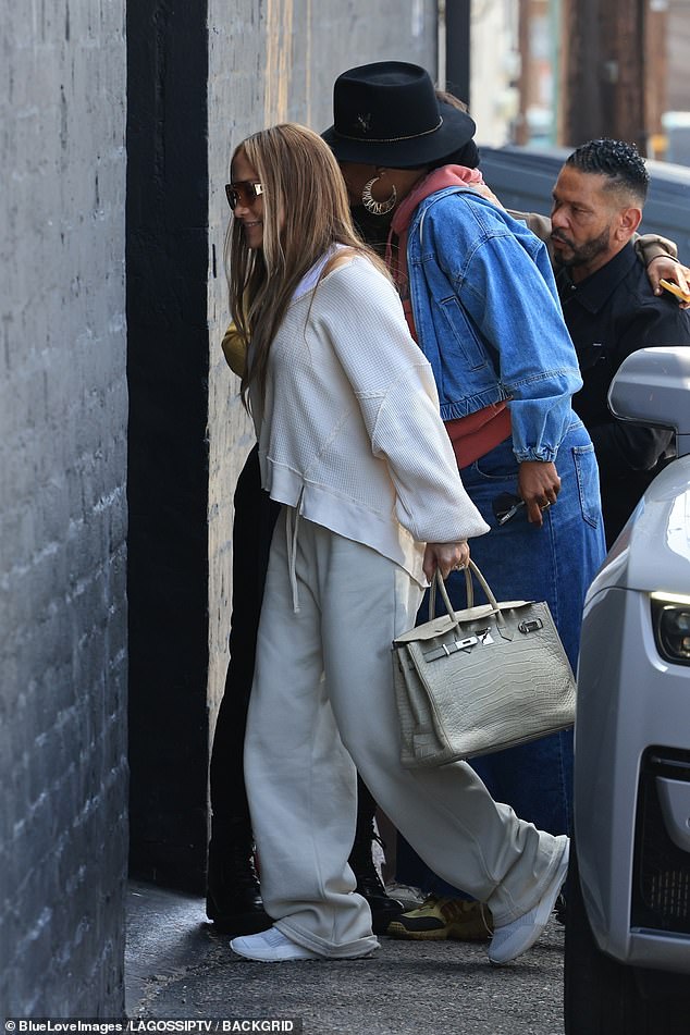 For the occasion, she wore an oversized white sweater over a matching tank top, sweatpants, sneakers and an oversized shades over her light brown eyes